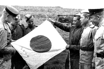 Фото: Бойцы рассматривают японский флаг, захваченный в бою